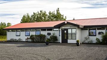 A building with a red roof and white exterior, featuring a reception area with a sign.