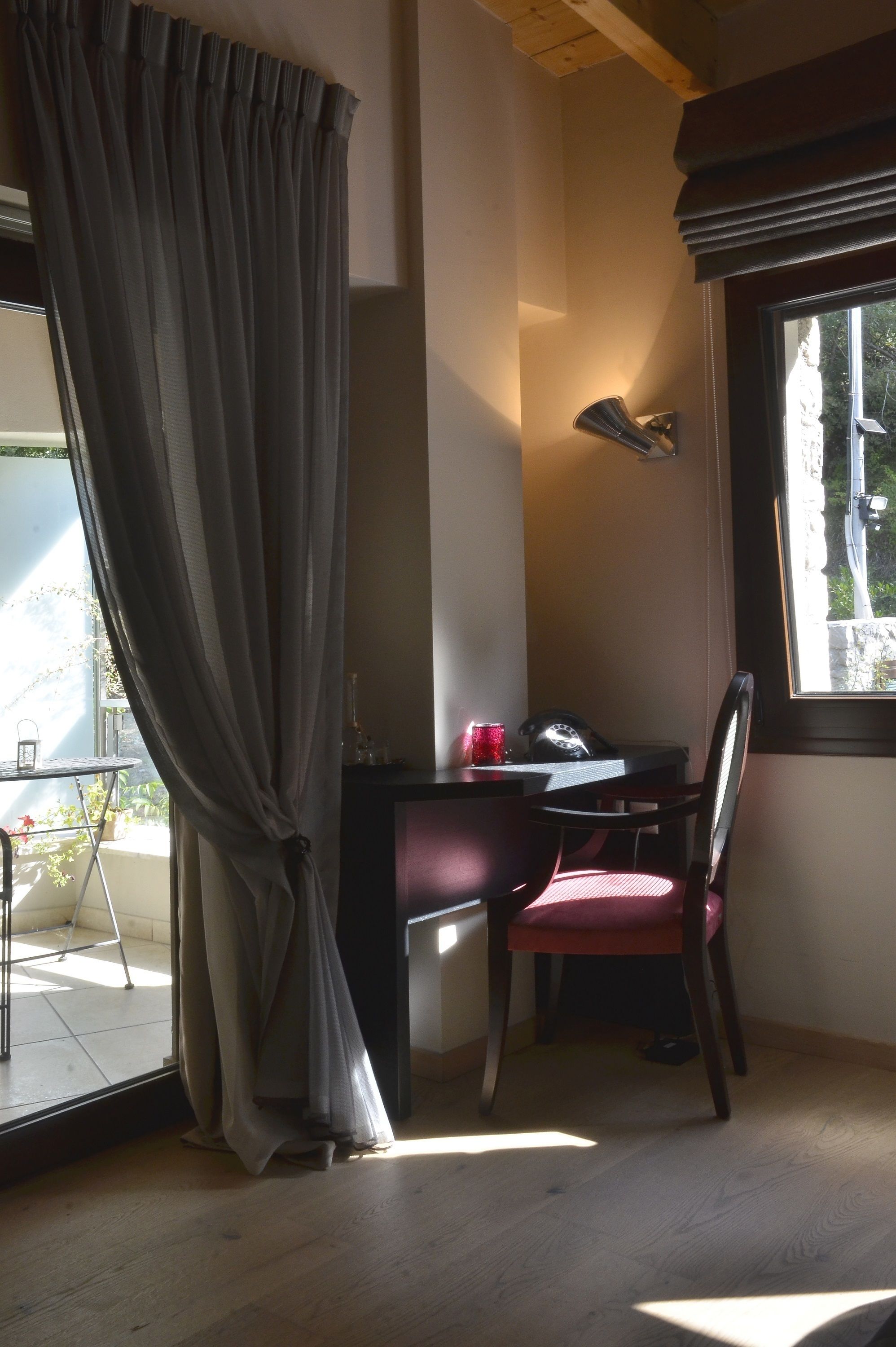 A room with a desk, chair, and a window with curtains.