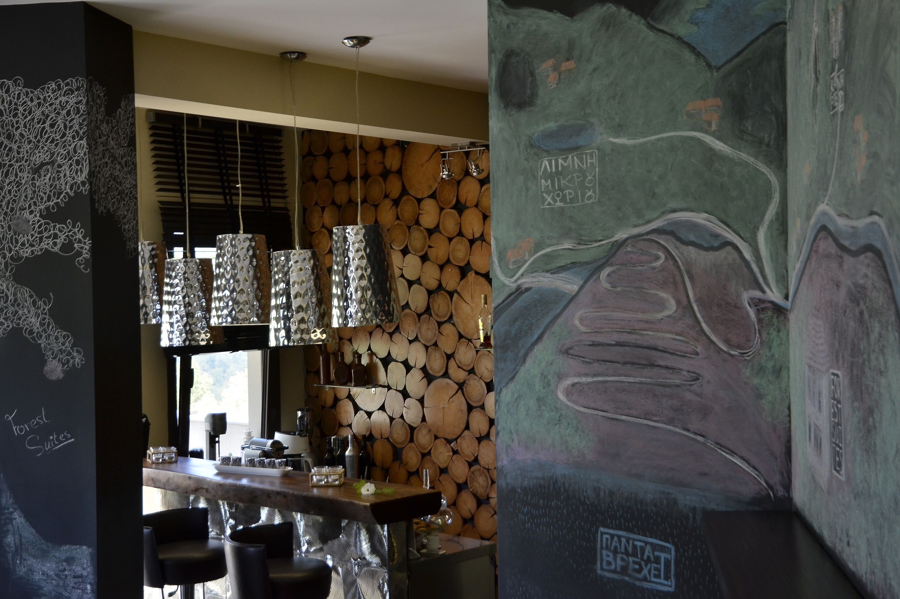 A bar area with a wooden log wall, hanging pendant lights, and a chalkboard menu.