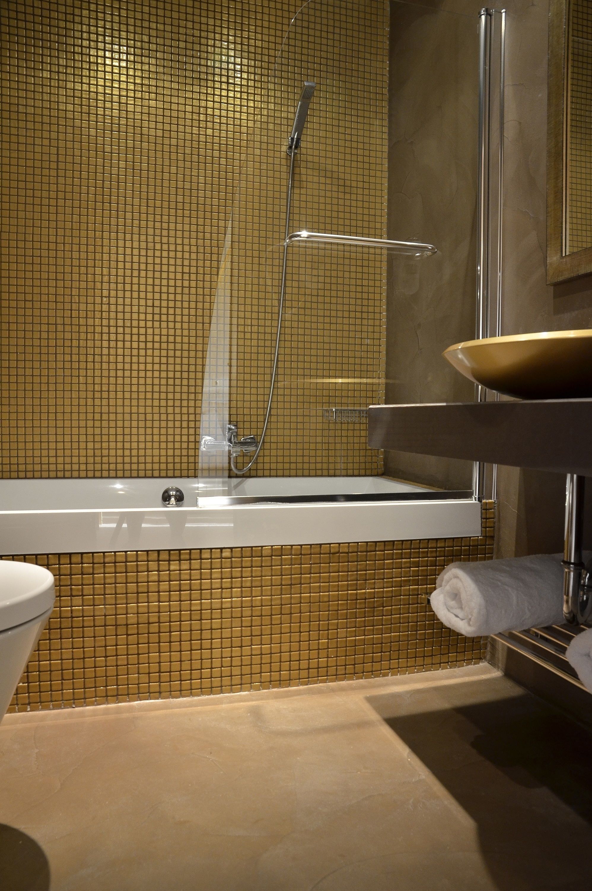 A modern bathroom with a bathtub, a glass-enclosed shower, and a sink with a bowl.