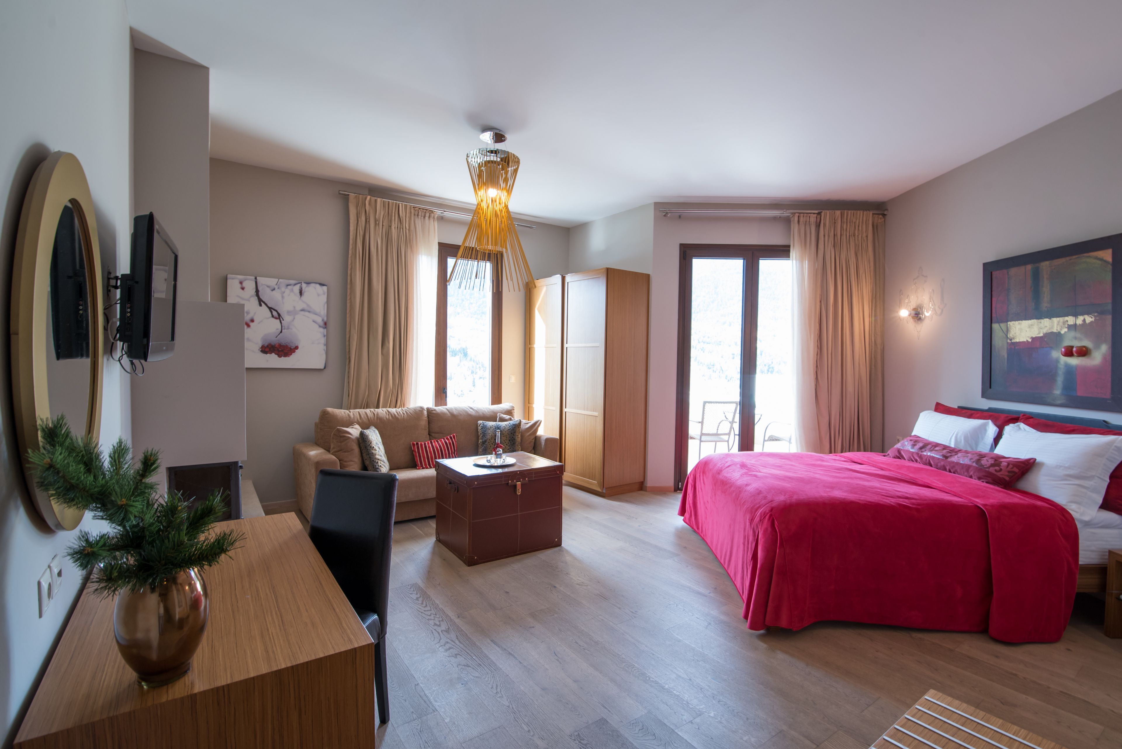 Una habitación de hotel moderna con cama, sofá, escritorio y una ventana grande.