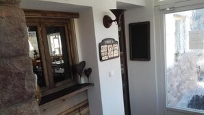 A room with a wooden bench, a mirror, a wall clock, and a window with frosted glass. - Hotel Pension Sonnalp (Ortisei)