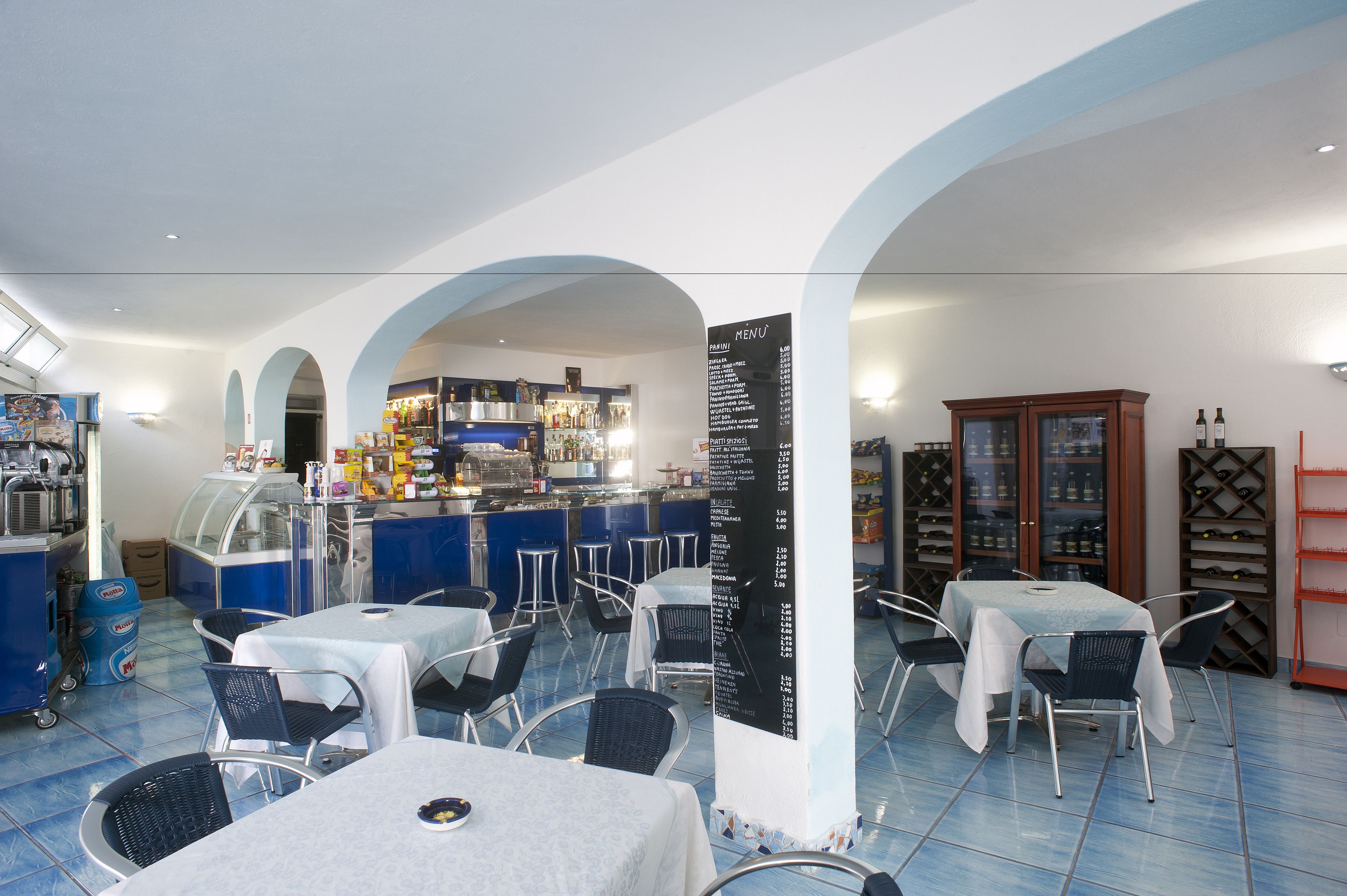 Ein Restaurant mit Barbereich, Tischen, Stühlen und einer Speisekarte.
