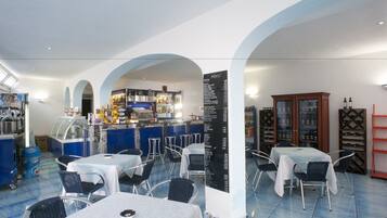Ein Restaurant mit Barbereich, Tischen, Stühlen und einer Speisekarte.
