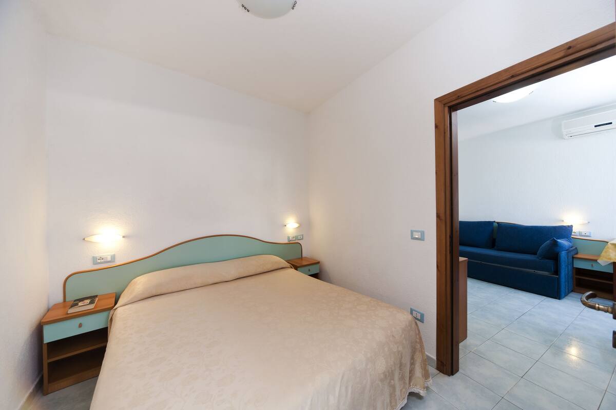Ein Schlafzimmer mit Bett, Nachttischen und einem Spiegel.