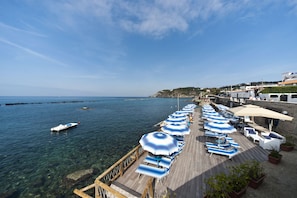 A pier with sun umbrellas and lounge chairs overlooking a clear blue sea. - La Rotonda Sul Mare (Forio)