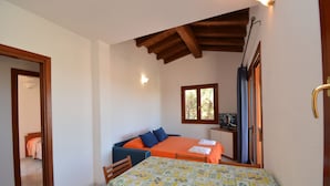 Quarto com cama, mesa e televisão.