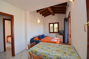 Departamento, 2 habitaciones, Terraza, vista al mar | Sala de estar | Televisión de 32 pulgadas con canales por cable