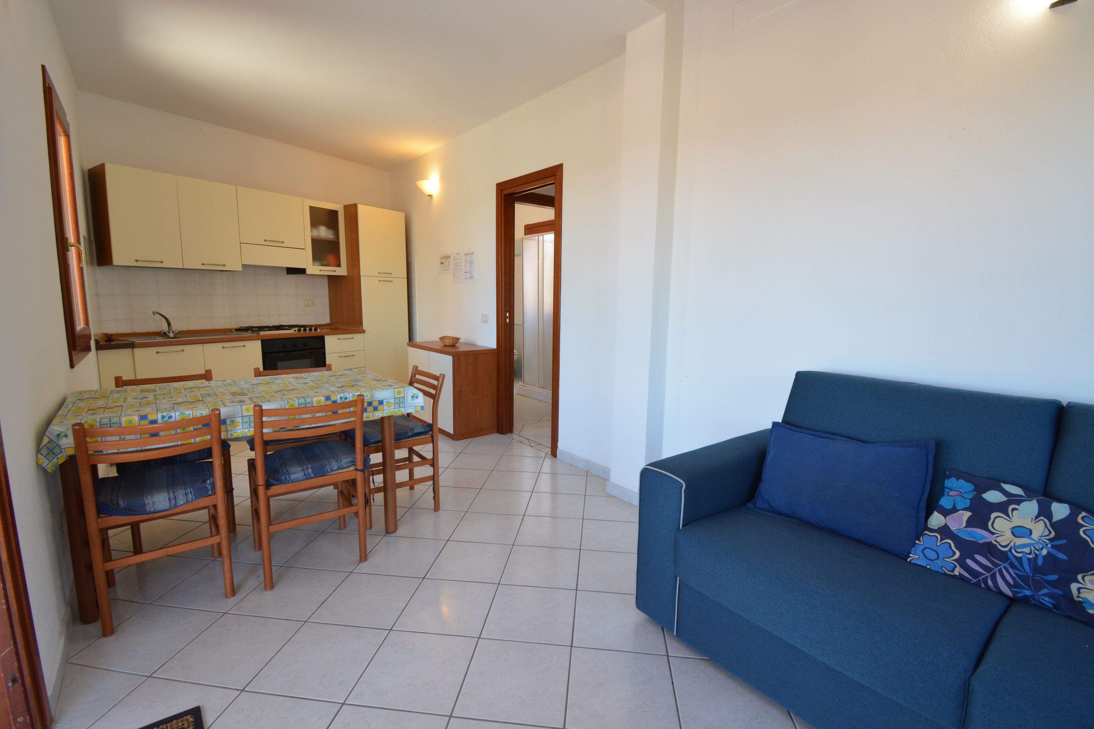 A compact living space with a dining area, kitchenette, and a sofa.