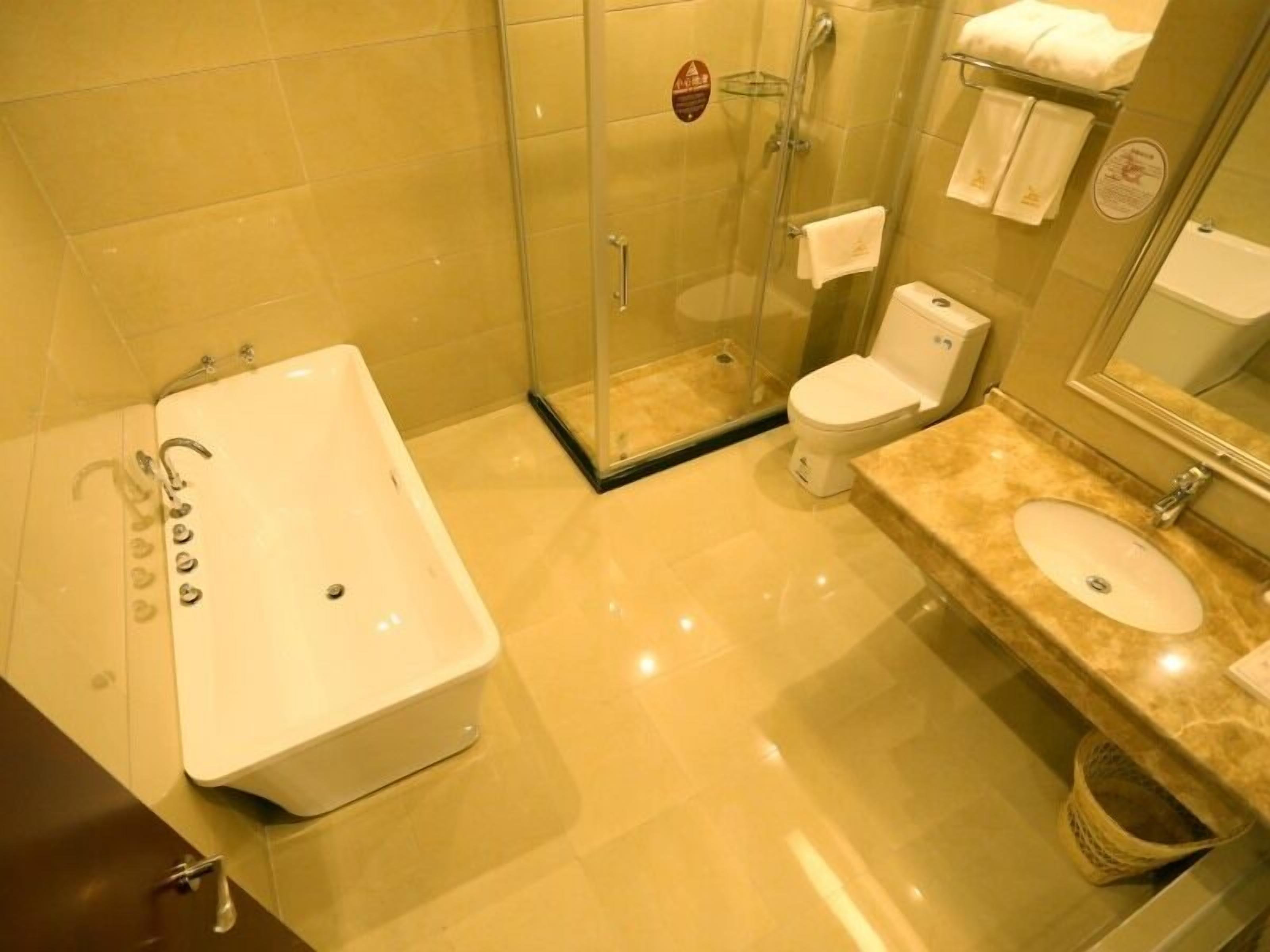 A modern bathroom with a large bathtub, a glass-enclosed shower, a toilet, and a vanity with a sink.