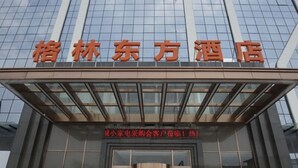A hotel entrance with a modern glass facade and a sign above the doors.
