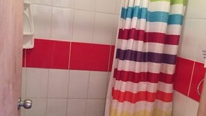 A small bathroom with a shower curtain, a toilet, and a tiled floor. - Cabaña en Algarrobo 4 El Canelo (Algarrobo)