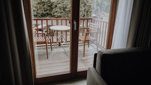 A balcony with a wooden deck, a round table, and two chairs. - Okelmann's (Warpe)