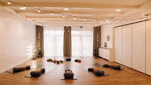 A spacious room with wooden flooring, yoga mats, and exercise equipment arranged for a fitness class. - Okelmann's (Warpe)