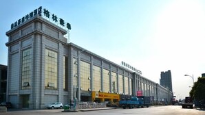 Um edifício grande e retangular com telhado plano e várias janelas.