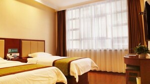 A hotel room with two beds, a desk, a chair, a television, and a large window with curtains. - GreenTree Inn HanZhong Railway Station BeiYiHuan Road Express Hotel (Hanzhong)
