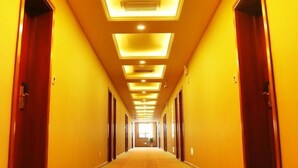 A hotel hallway with multiple doors and a carpeted floor. - GreenTree Inn HanZhong Railway Station BeiYiHuan Road Express Hotel (Hanzhong)