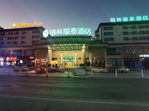 A hotel with a prominent sign, a parking lot, and a KFC restaurant nearby.