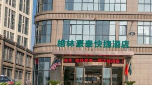 A hotel with a green signboard and a curved facade. - Greentree Inn (Suzhou)