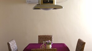 A dining area with a table covered by a purple cloth, two patterned chairs, and a decorative item on the table. - GreenTree Alliance Shenzhen Fuyong Metro Station Hotel (Shenzhen)