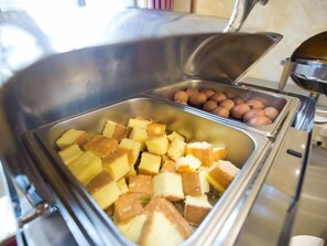 Un bufé con diversos alimentos, incluyendo pan, bollería y huevos cocidos.