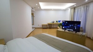 A hotel room with a bed, a desk, a television, and a window with curtains. - GreenTree Inn Hefei Feixi County South Jinzhai Road Jinyun International Hotel (Hefei)