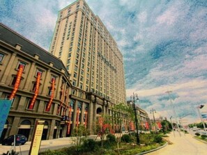 Un immeuble imposant à l’architecture moderne, entouré d’un quartier urbain bien aménagé, avec un ciel dégagé.