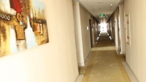 Een hotelgang met vloerbedekking en een lange hal.