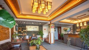 Eine Lobby mit einer Ledersofa, einem Holztisch und einer Rezeption.