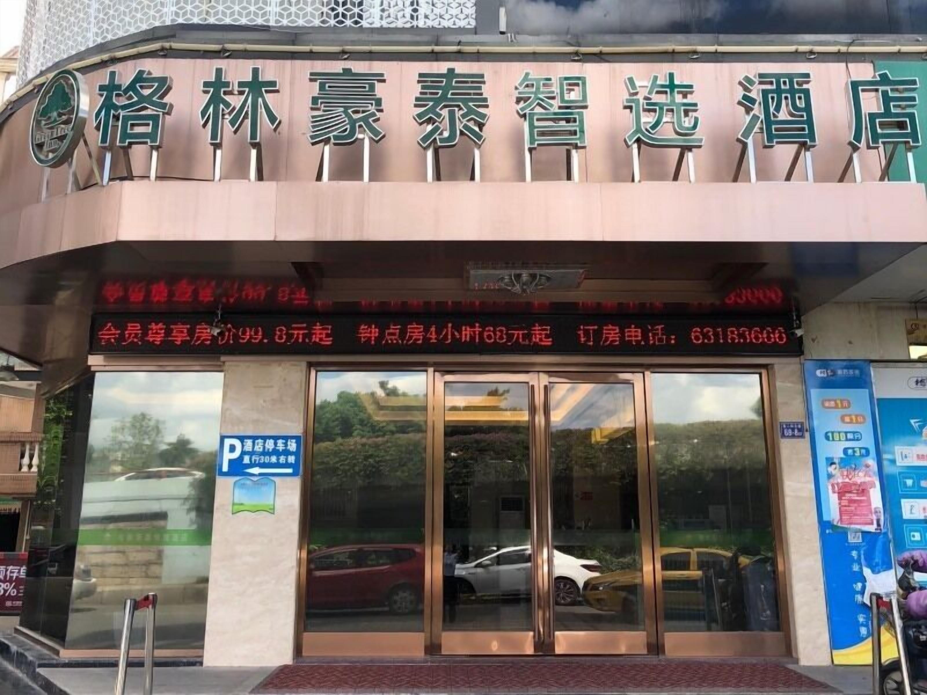 A hotel entrance with a signboard displaying the name and amenities.