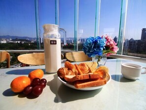 A breakfast table with a bottle of milk, a plate of toast, grapes, and a vase of flowers. - GreenTree Inn Fuzhou Gushilou District North Xierhuan Road Zuohai park Express Hotel (Fuzhou)