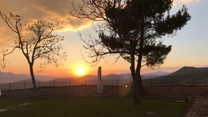 Una vista del atardecer con un camino de piedra y árboles.