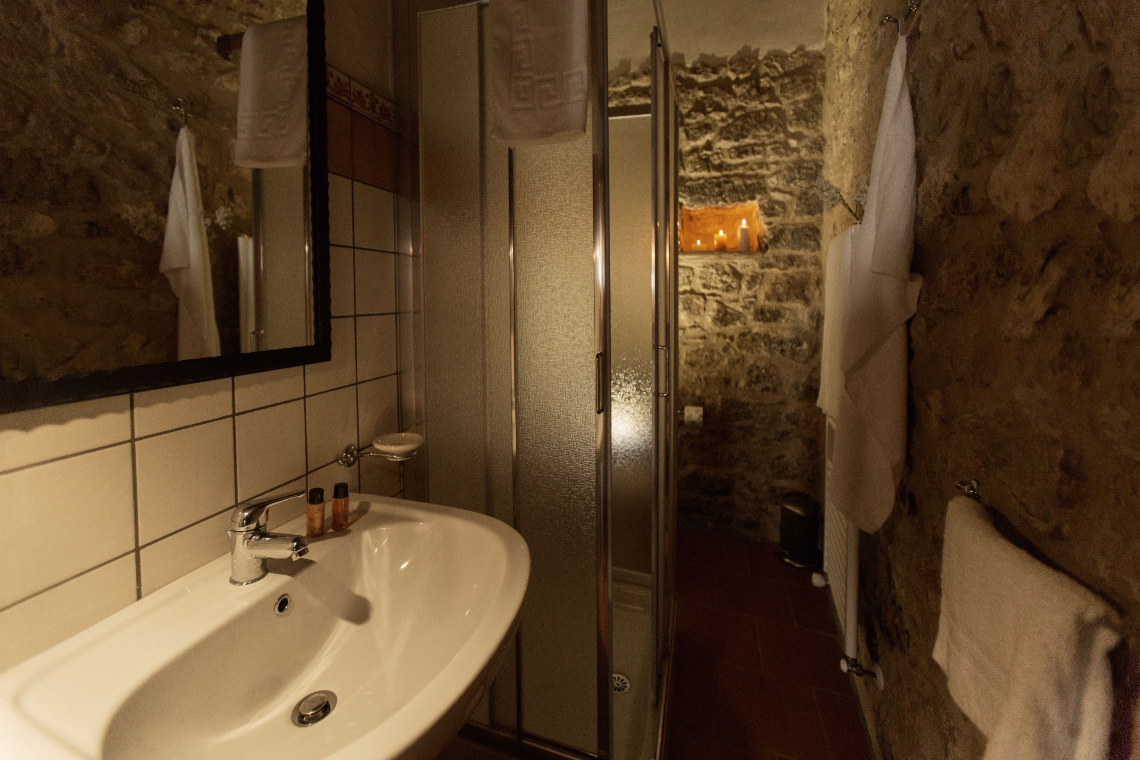 A bathroom with a white sink, a mirror, and a shower area.