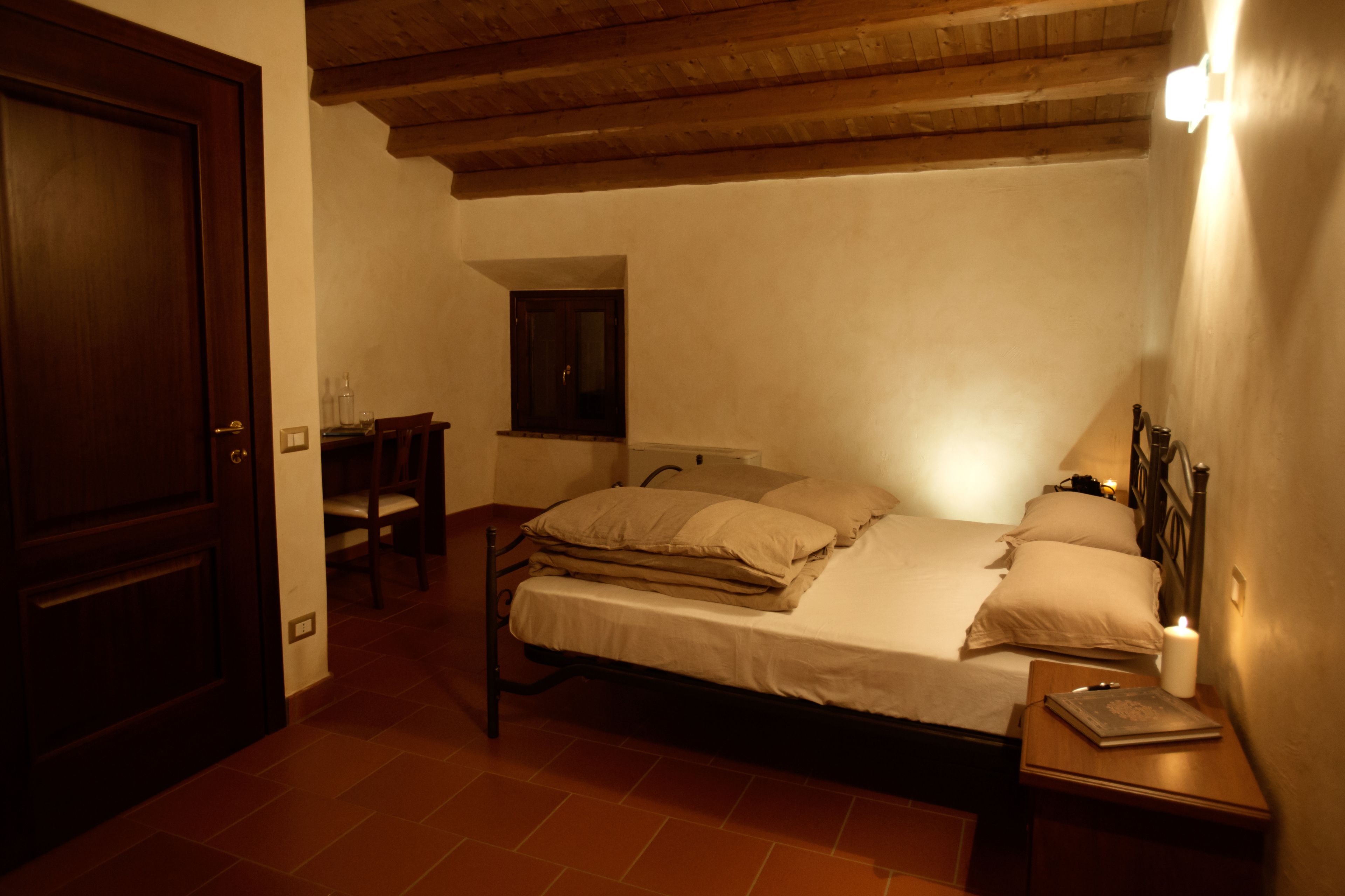 Ein Schlafzimmer mit Bett, Nachttisch und Fenster.