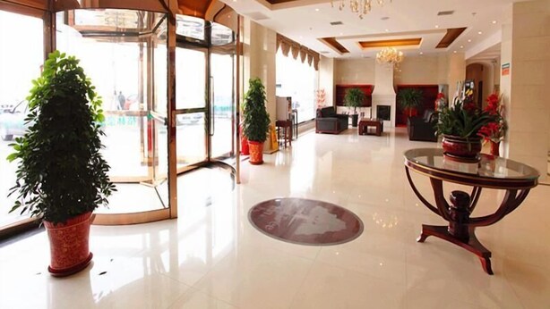 A hotel lobby with a revolving door, a chandelier, and potted plants. - GreenTree Inn Tianjin Wuqing District West Yongyang Road Florentia Village Express Hotel (Tianjin)