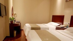 A hotel room with two beds, a bedside table with a lamp, a small desk with a chair, and a potted plant. - GreenTree Inn Tianjin Wuqing District West Yongyang Road Florentia Village Express Hotel (Tianjin)