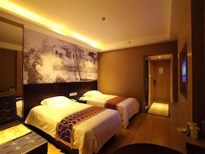 Una habitación de hotel con dos camas, un mural grande en la pared y suelo de madera.