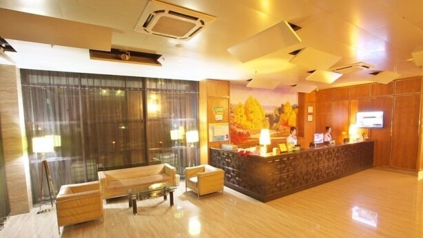 A modern hotel lobby with a reception desk, seating area, and large windows. - GreenTree Inn Huzhou Wuxing District South Street Chaoyin Bridge Business Hotel (Huzhou)