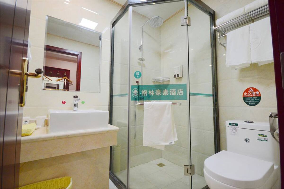 Une salle de bain d’hôtel avec une douche à parois de verre, un lavabo et des toilettes.