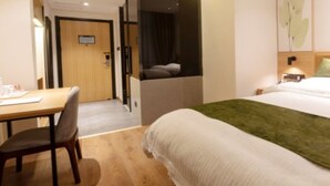 Une chambre d’hôtel avec un lit, un bureau et une chaise.