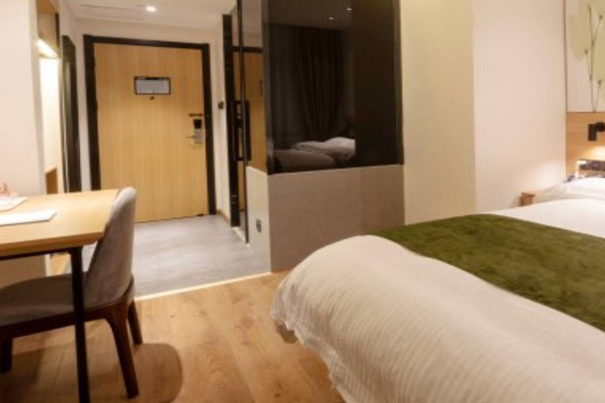 Una habitación de hotel con una cama, un escritorio y una silla.