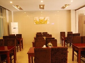 A conference room with rows of wooden chairs and tables, a whiteboard, and a wall-mounted air conditioning unit. - GreenTree Inn Hefei Wuhu Road Wanda Plaza Express Hotel (Hefei)