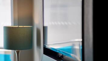 A window with a view of a pool and a lamp.