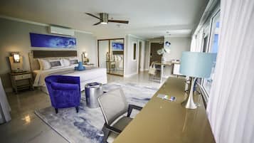A modern hotel room with a bed, a desk, a chair, and a ceiling fan.