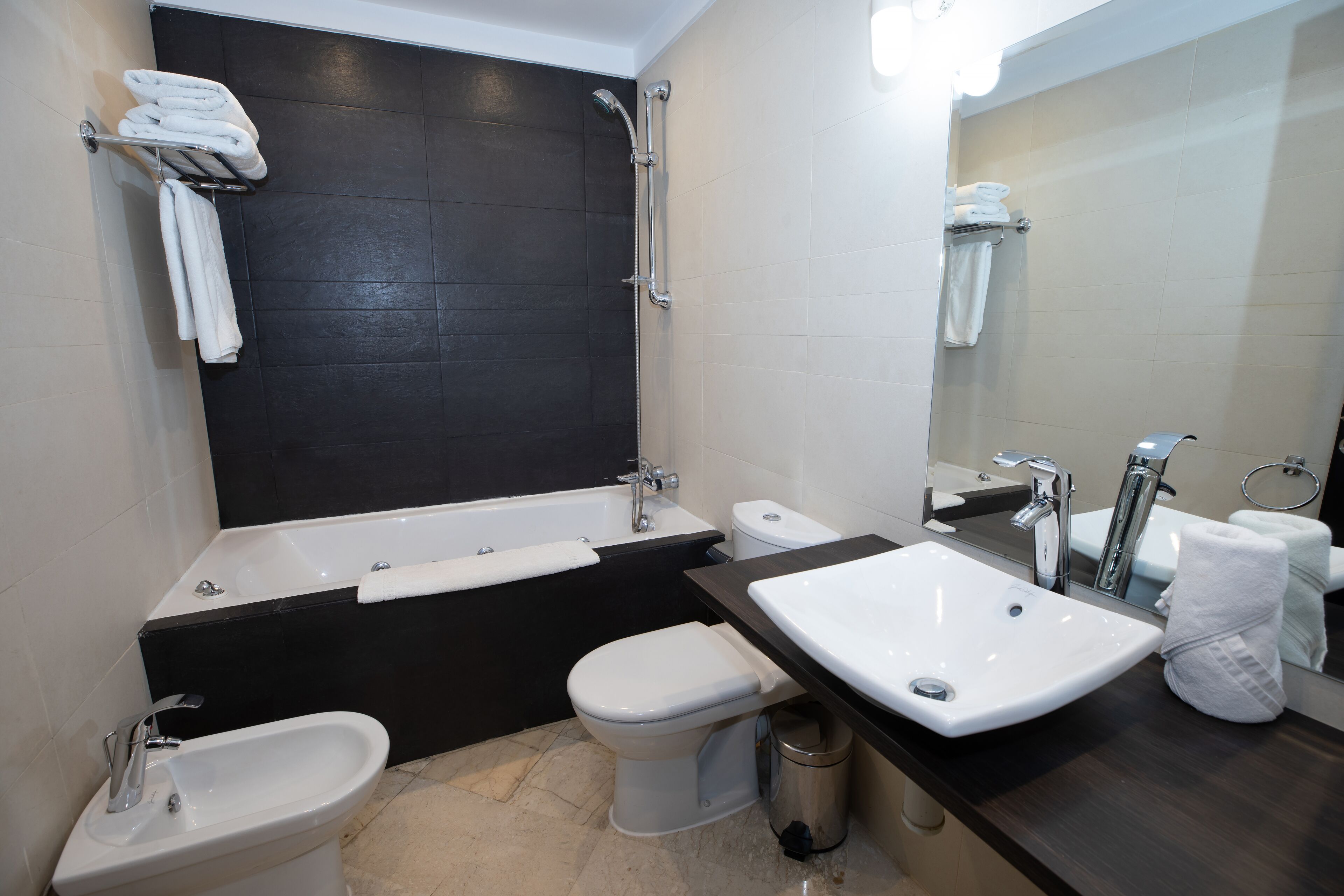 A modern bathroom with a bathtub, a bidet, a toilet, and a sink.