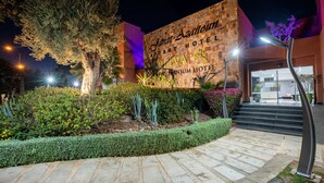 The exterior of Jantar Azaitoun Apartment Hotel with a stone facade, a well-maintained garden, and a staircase leading to the entrance. - Condominium Hotel Resorts Oliva (Marrakech)