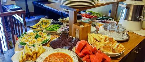 A buffet table with various dishes including eggs, meat, and vegetables.