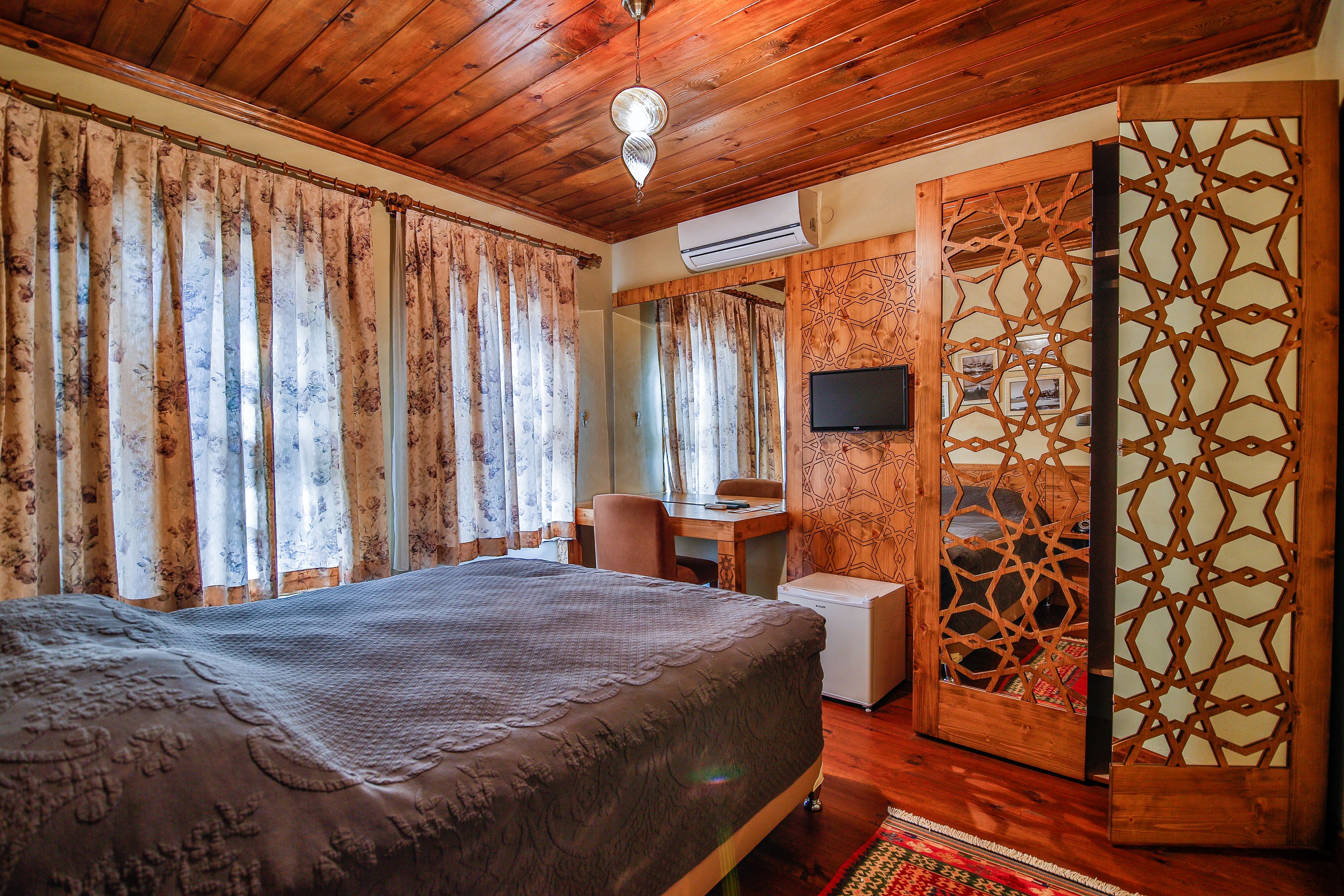 Un dormitorio con cama, escritorio, silla y televisor.