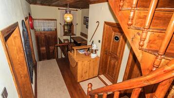 Una escalera de madera con barandilla de madera y una puerta de madera con un ventanal redondo.