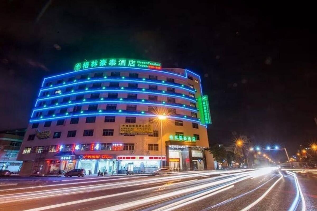 Un hotel de varios pisos con señalización iluminada y fachada curva.